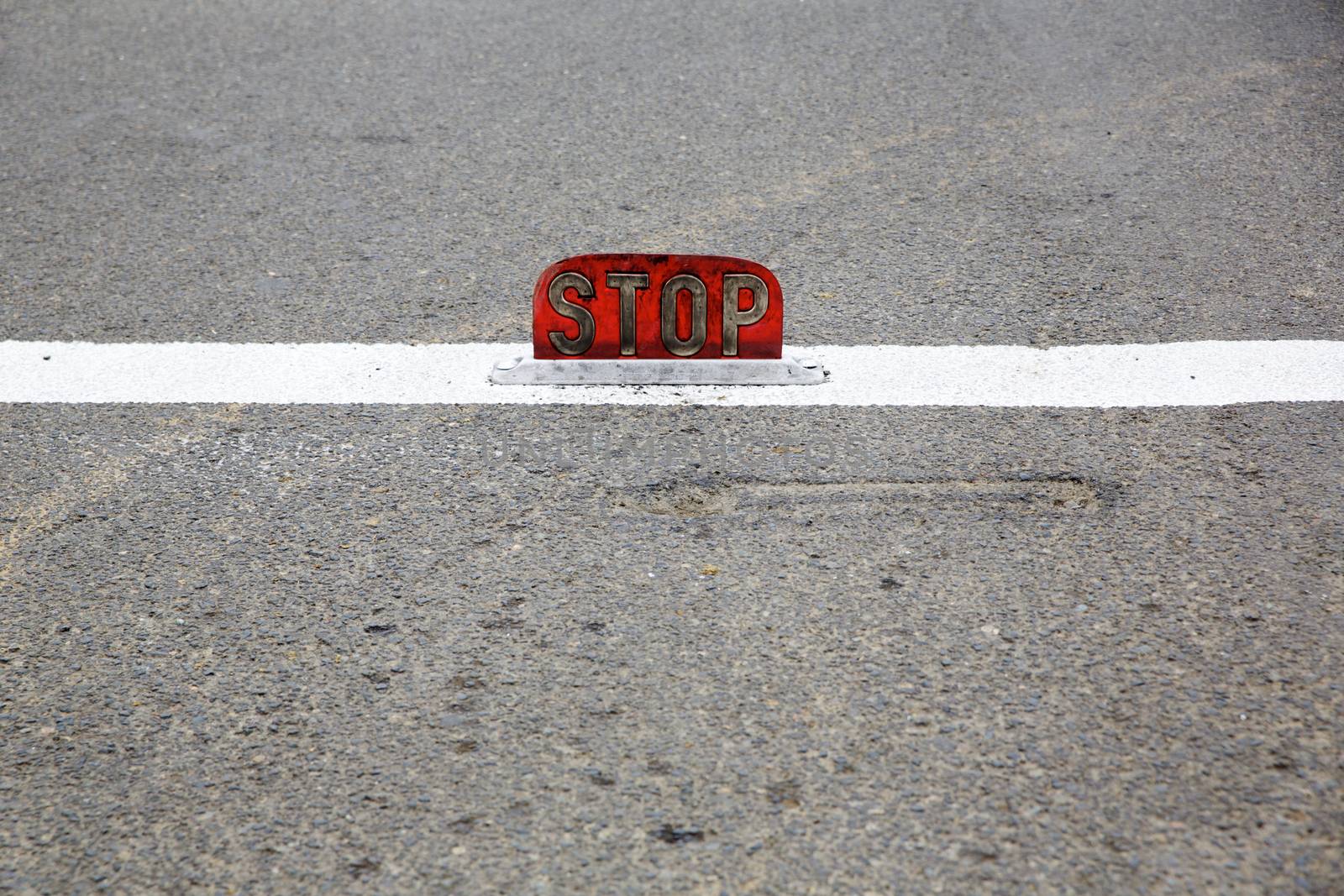 Old road stop sign mounted on asphalt