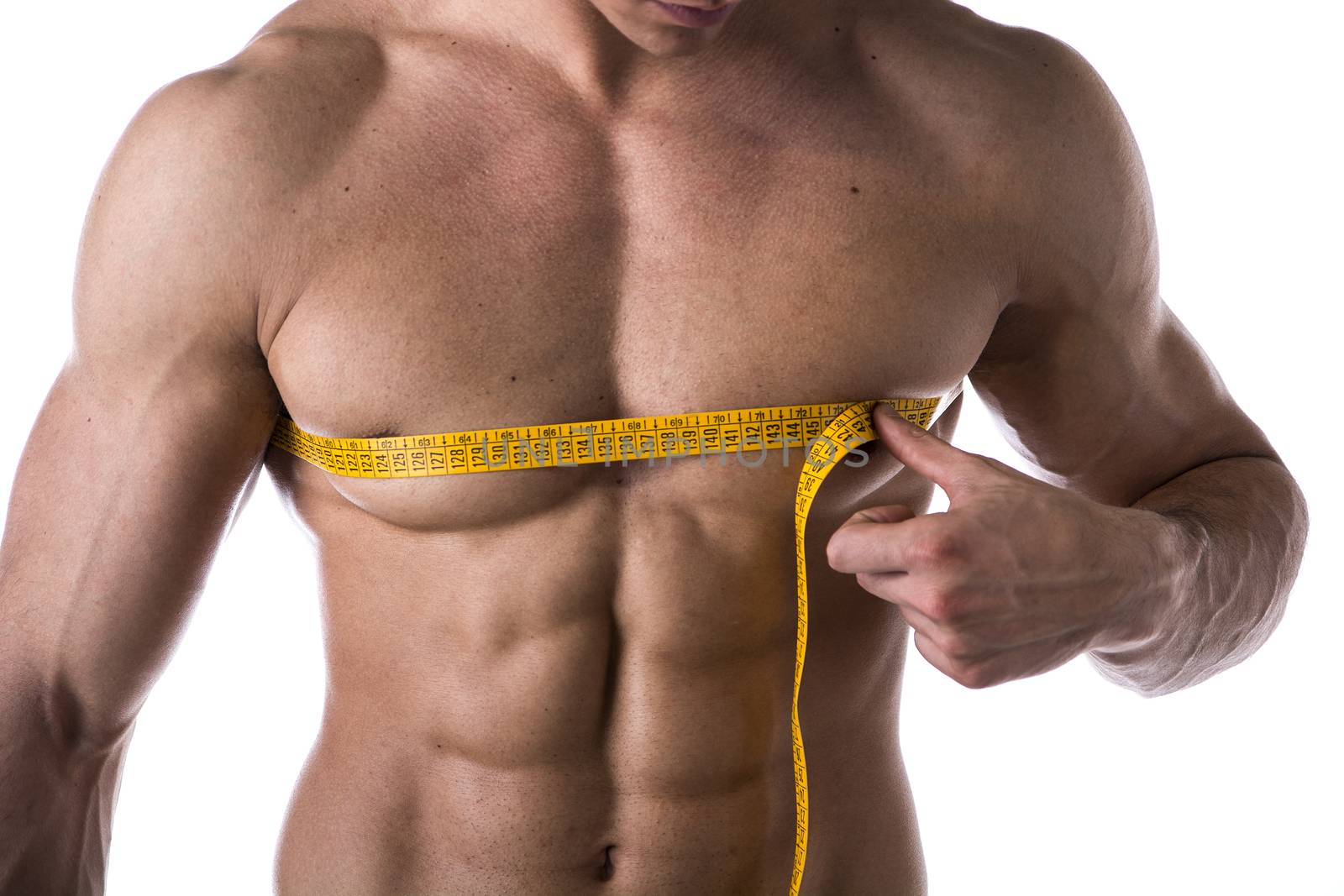 Muscular shirtless young man measuring chest and pecs with tape measure, close-up of torso on white