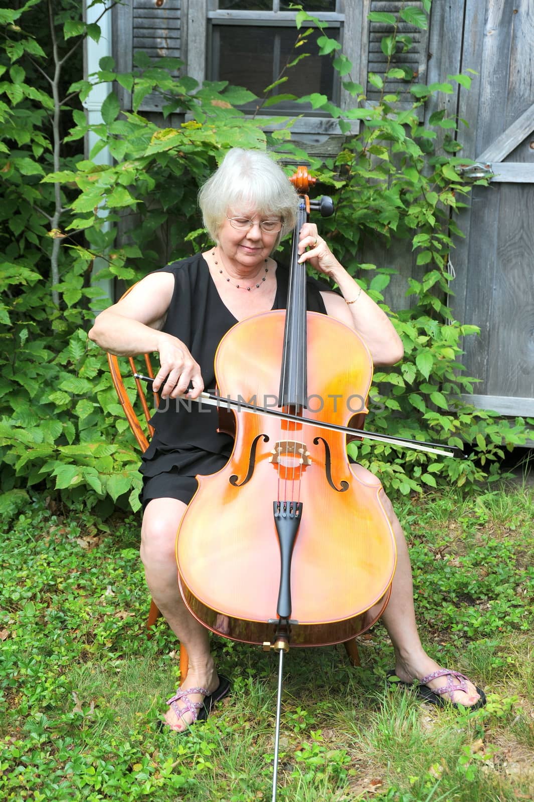 Female cellist performing a classical piece outside.