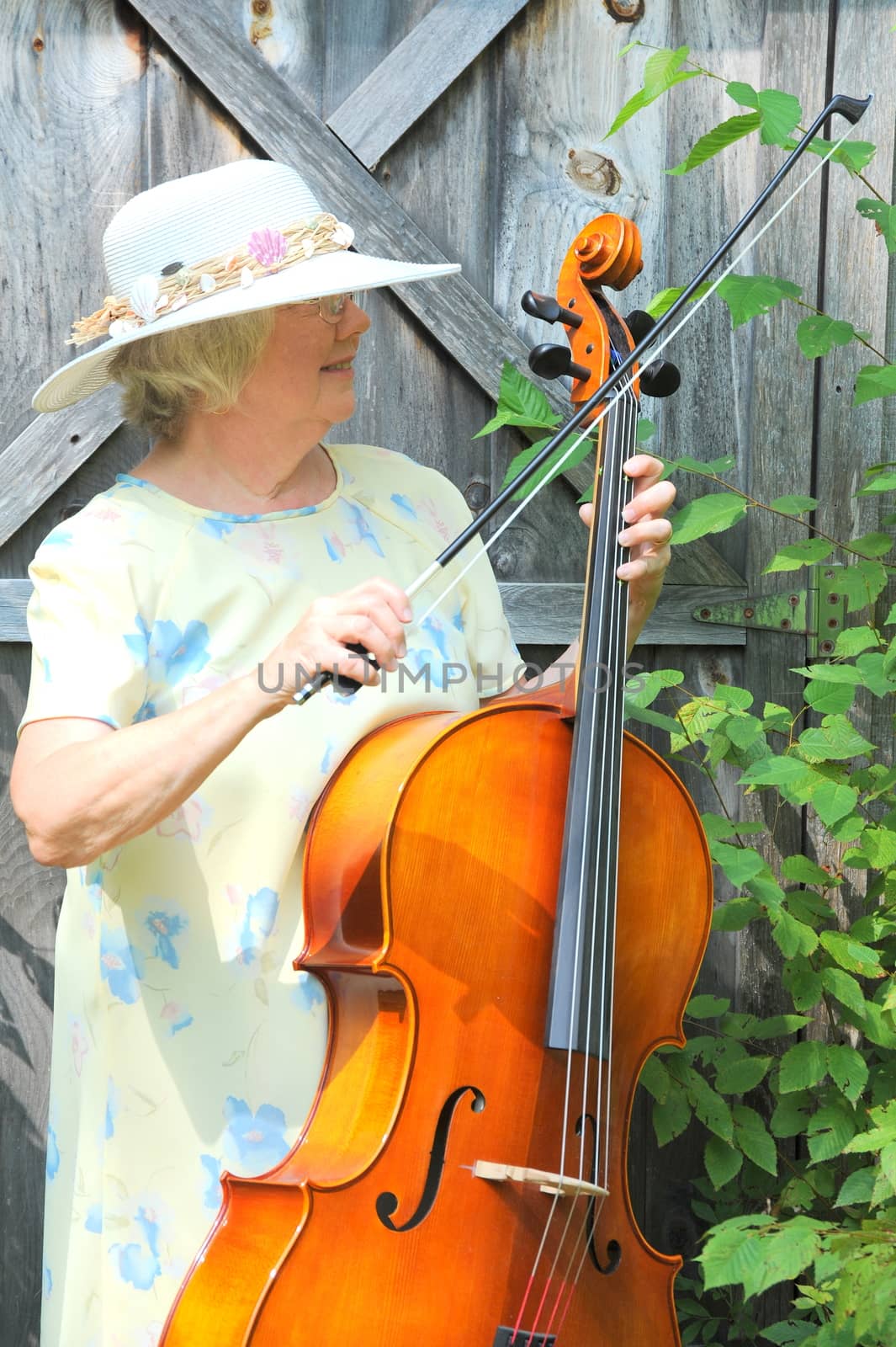 Female cellist performing a classical piece outside.