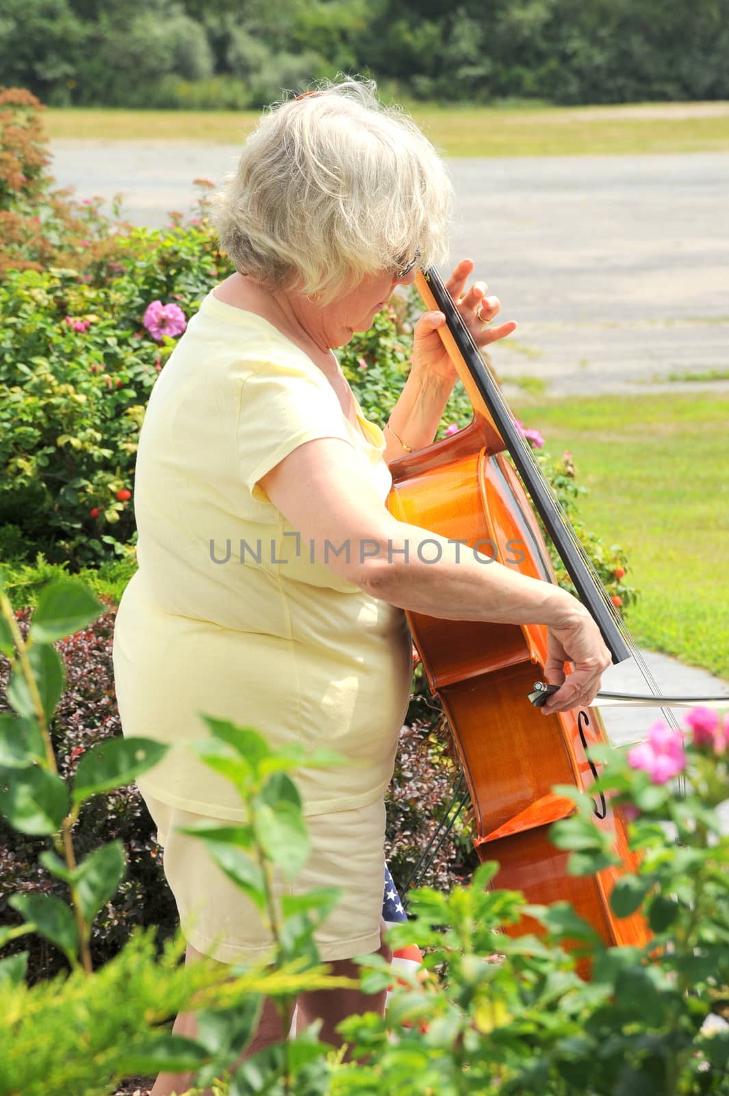 Female cellist performing a classical piece outside.