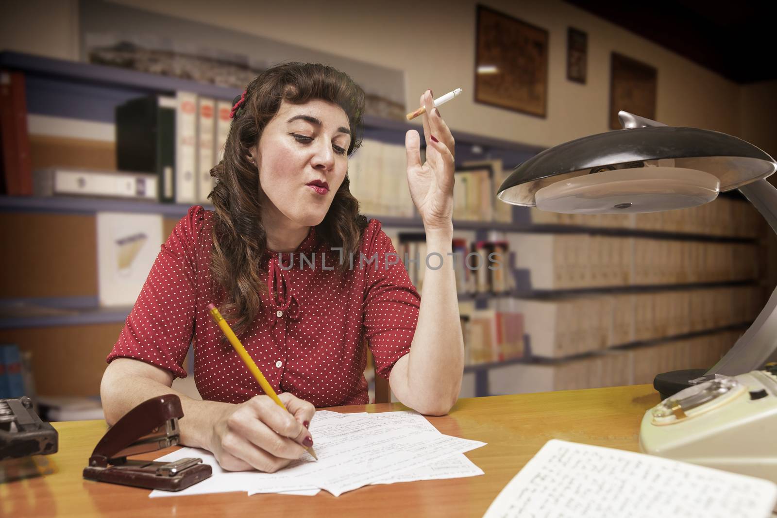 young Secretary smoking a cigarette while typing in your address book, 1960's scene