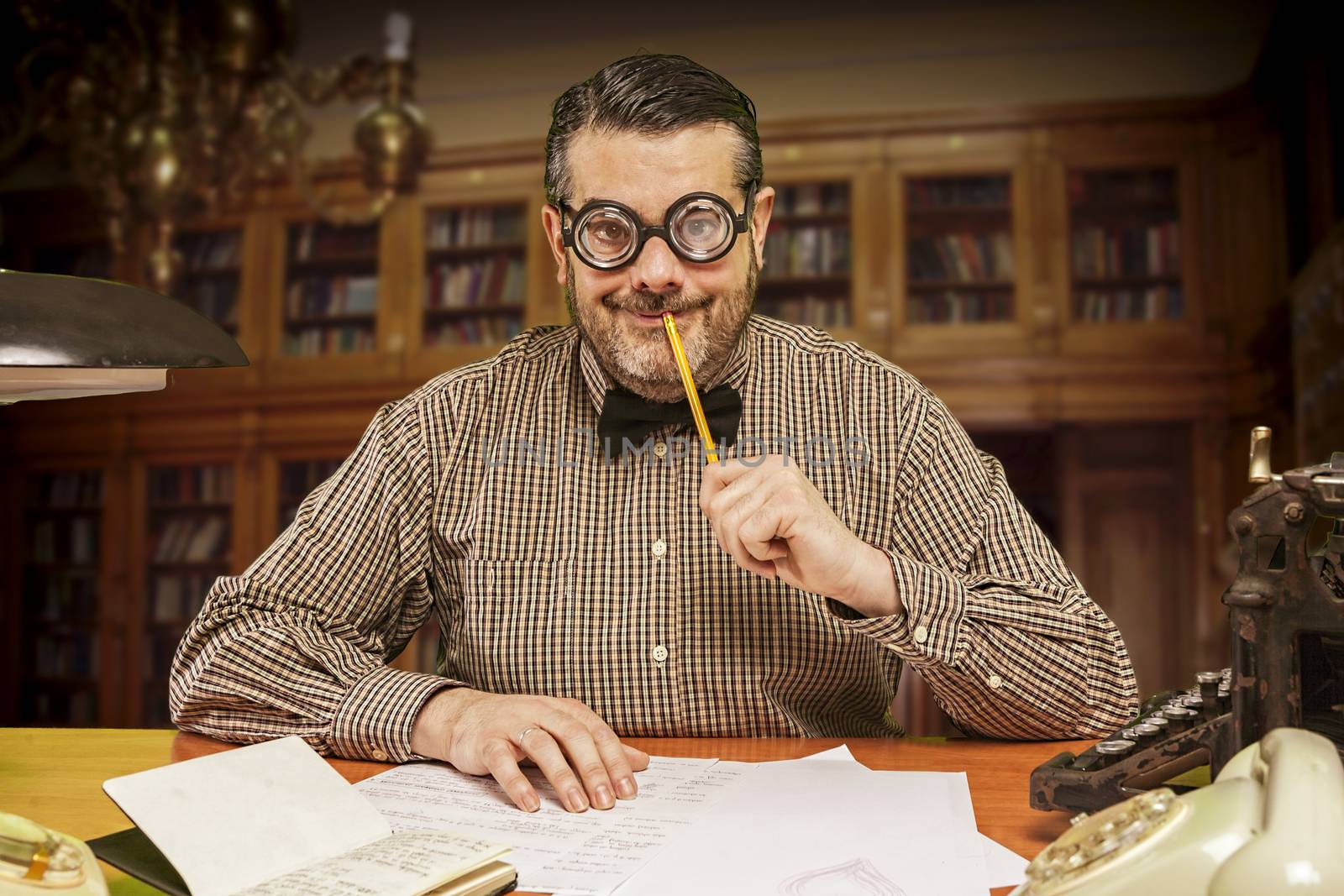 Pensive office employee with a pencil in his mouth looking up in by digicomphoto