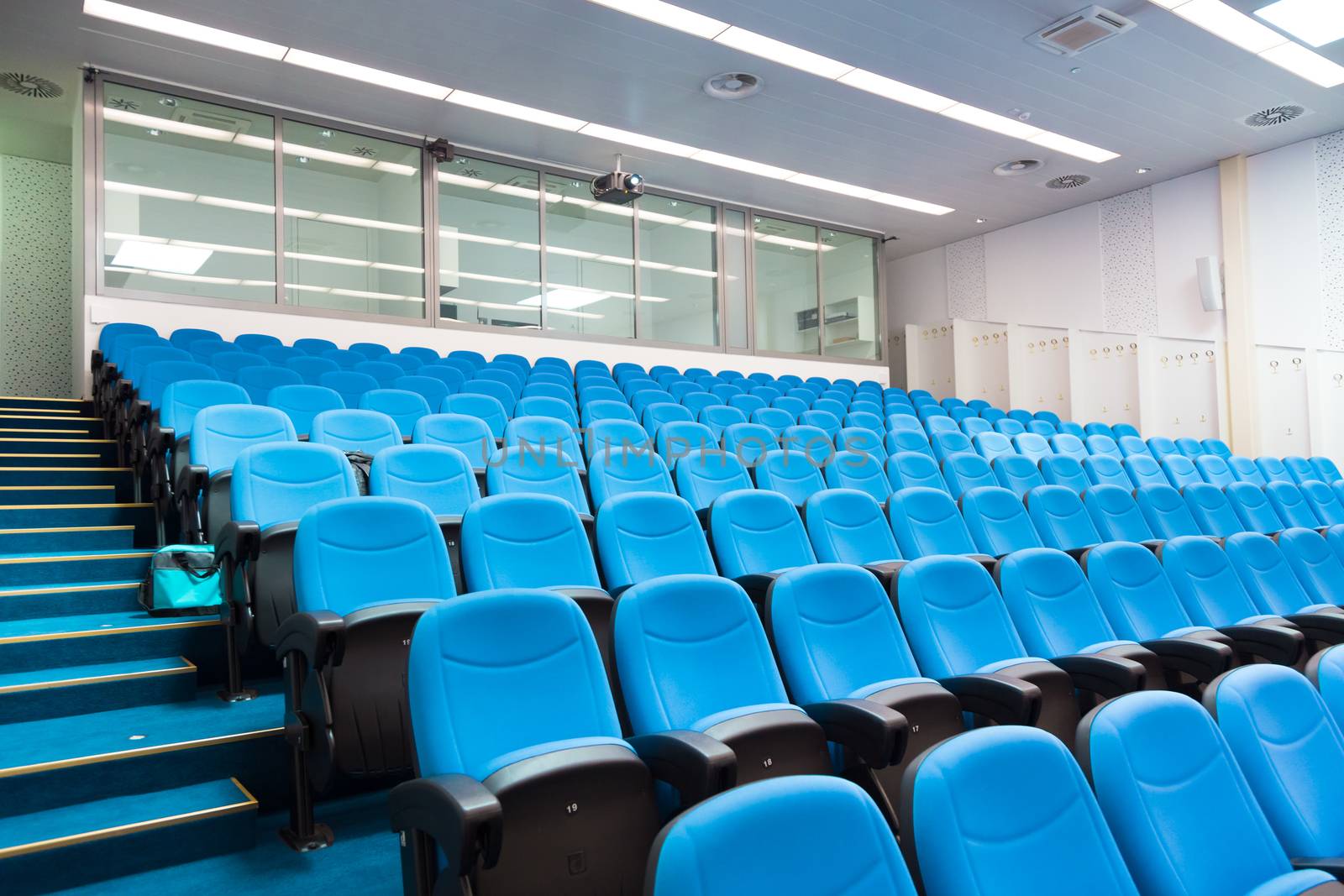 Interior of empty conference hall with blue velvet chairs.