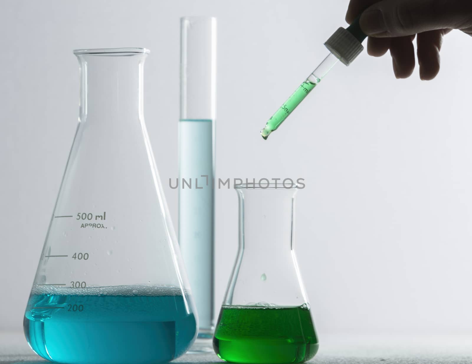 Laboratory glassware and arm with pipette  by digicomphoto