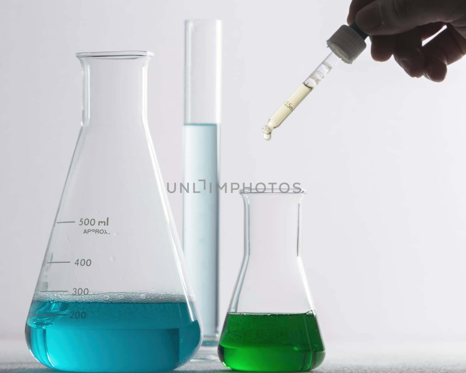 Laboratory glassware and arm with pipette 