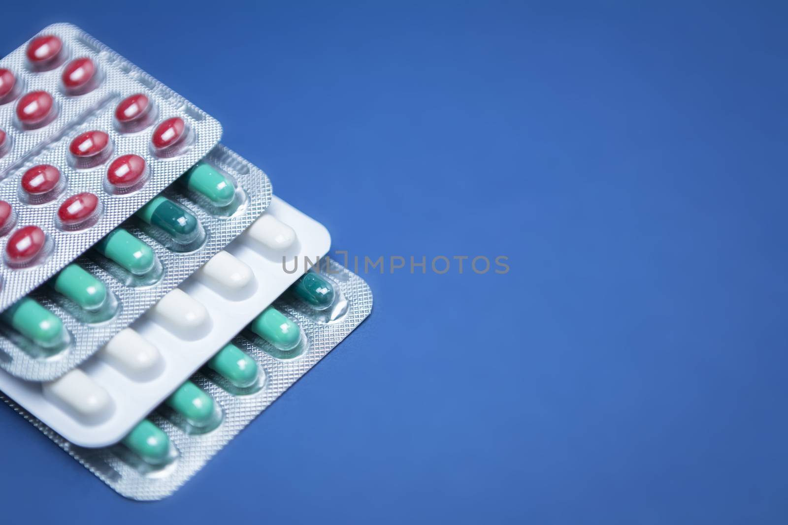 Some pills aligned isolated on blue background by digicomphoto