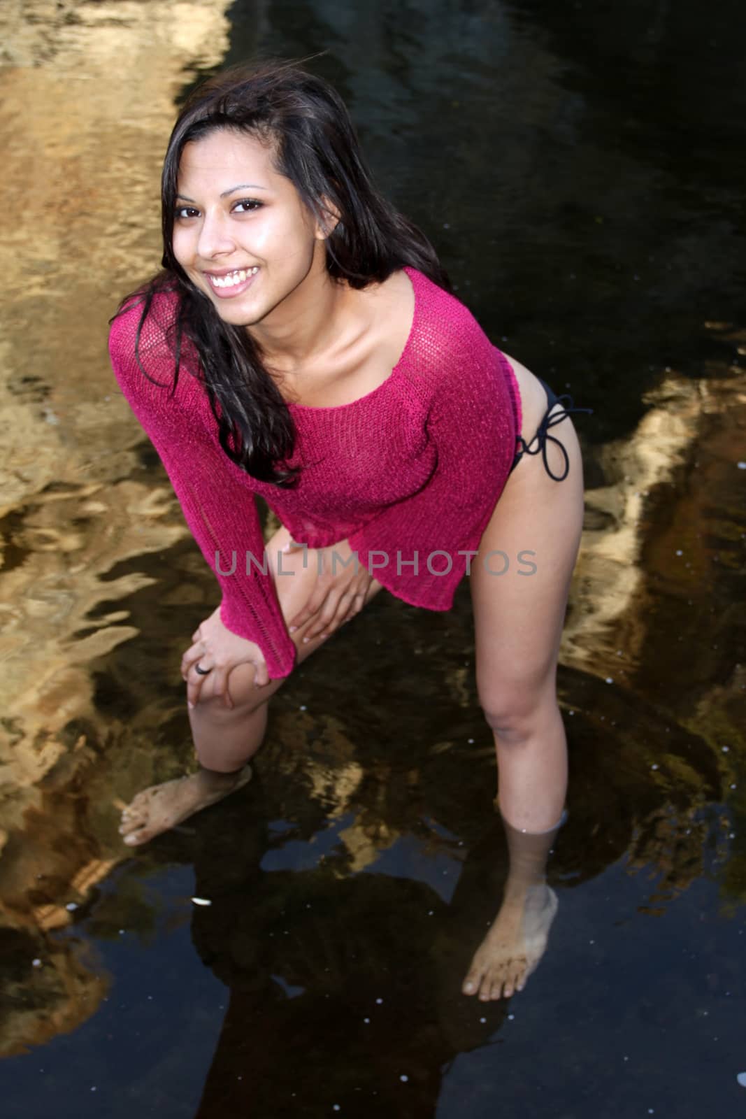 Hispanic woman standing in creek water.