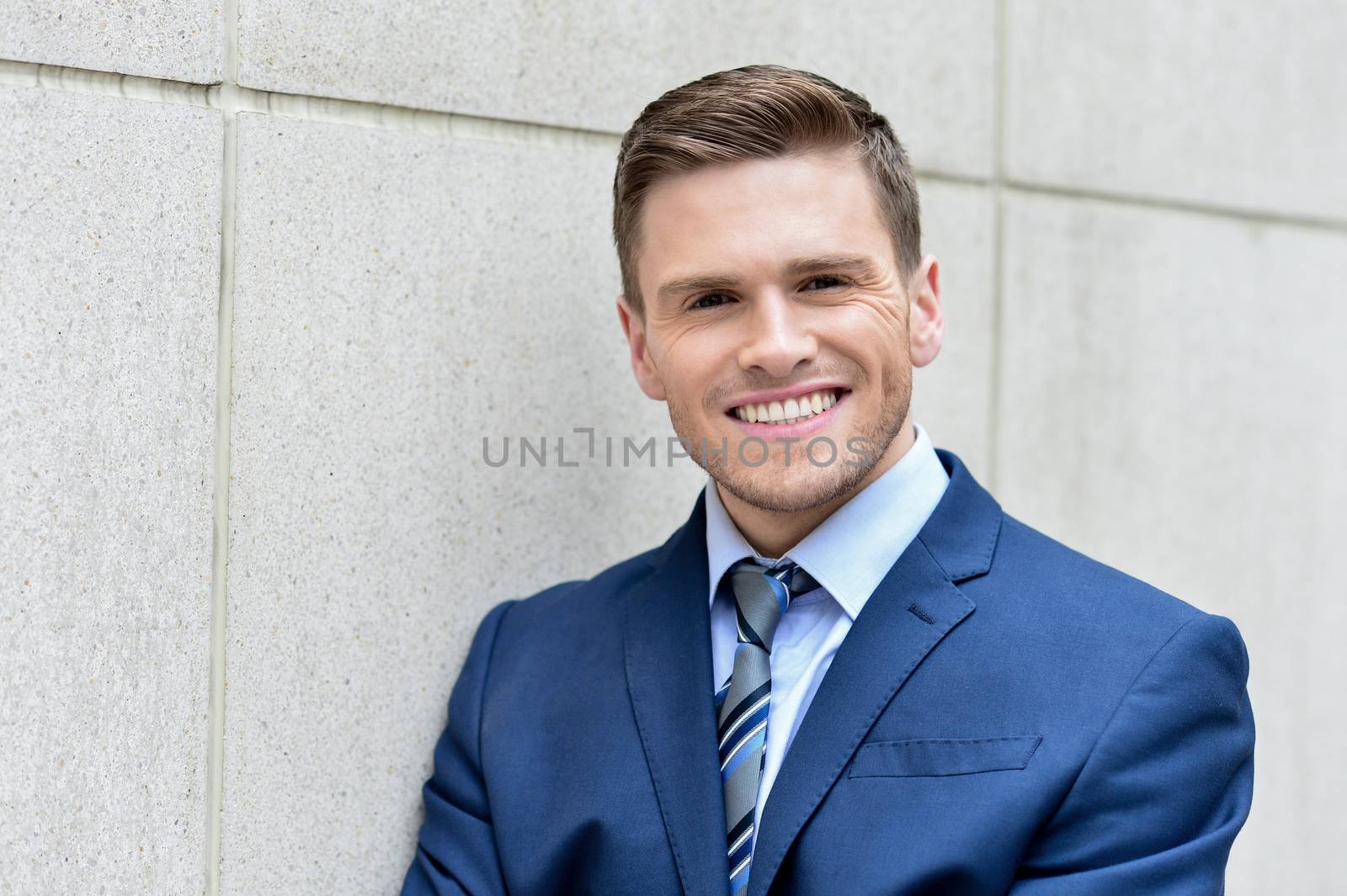 Smiling young businessman posing at outdoors