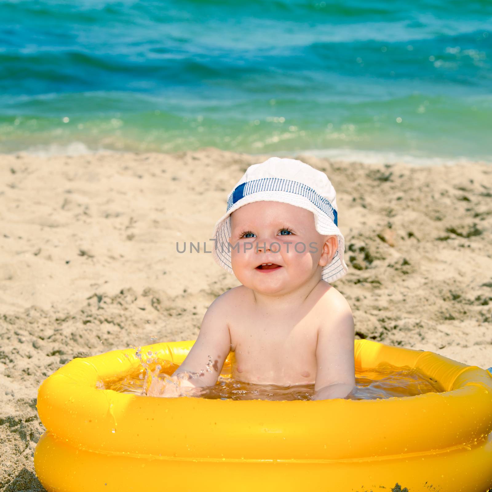 Happy baby boy playing on a beach