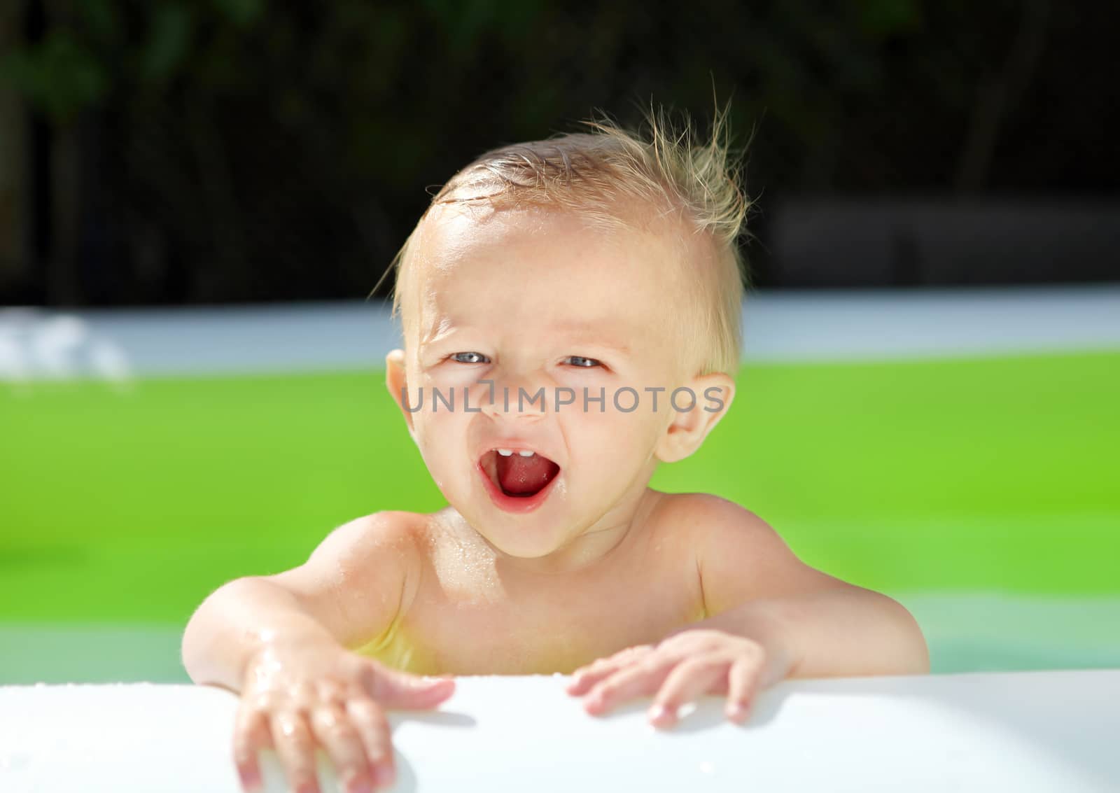 Playful Baby Boy in the Pool at Sunny Summer Day