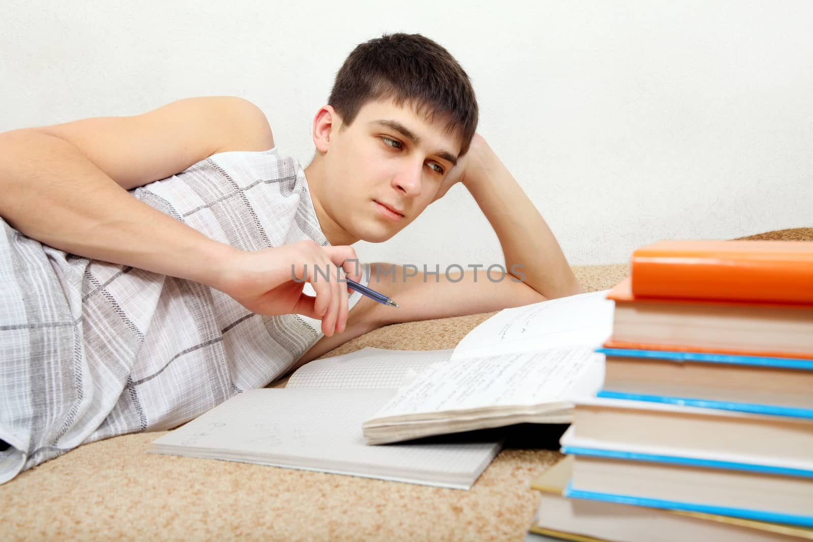 Teenager preparing for Exam on the Bed at the Home