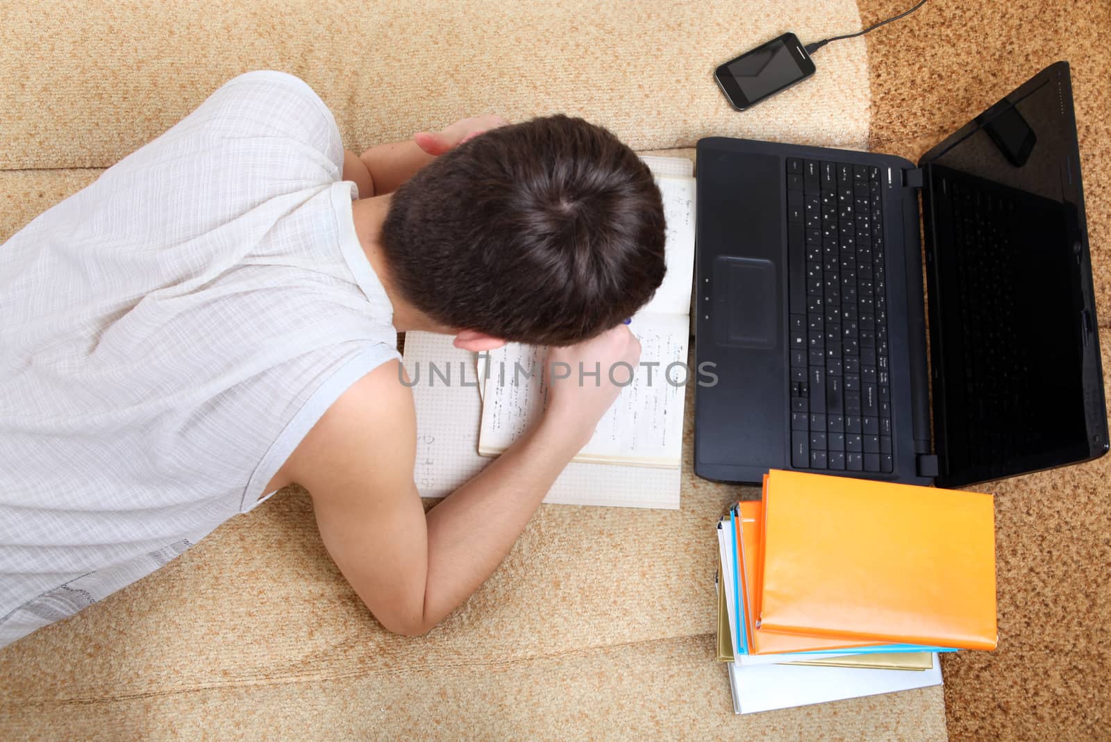 Upper view of Teenager preparing for Exam at the Home