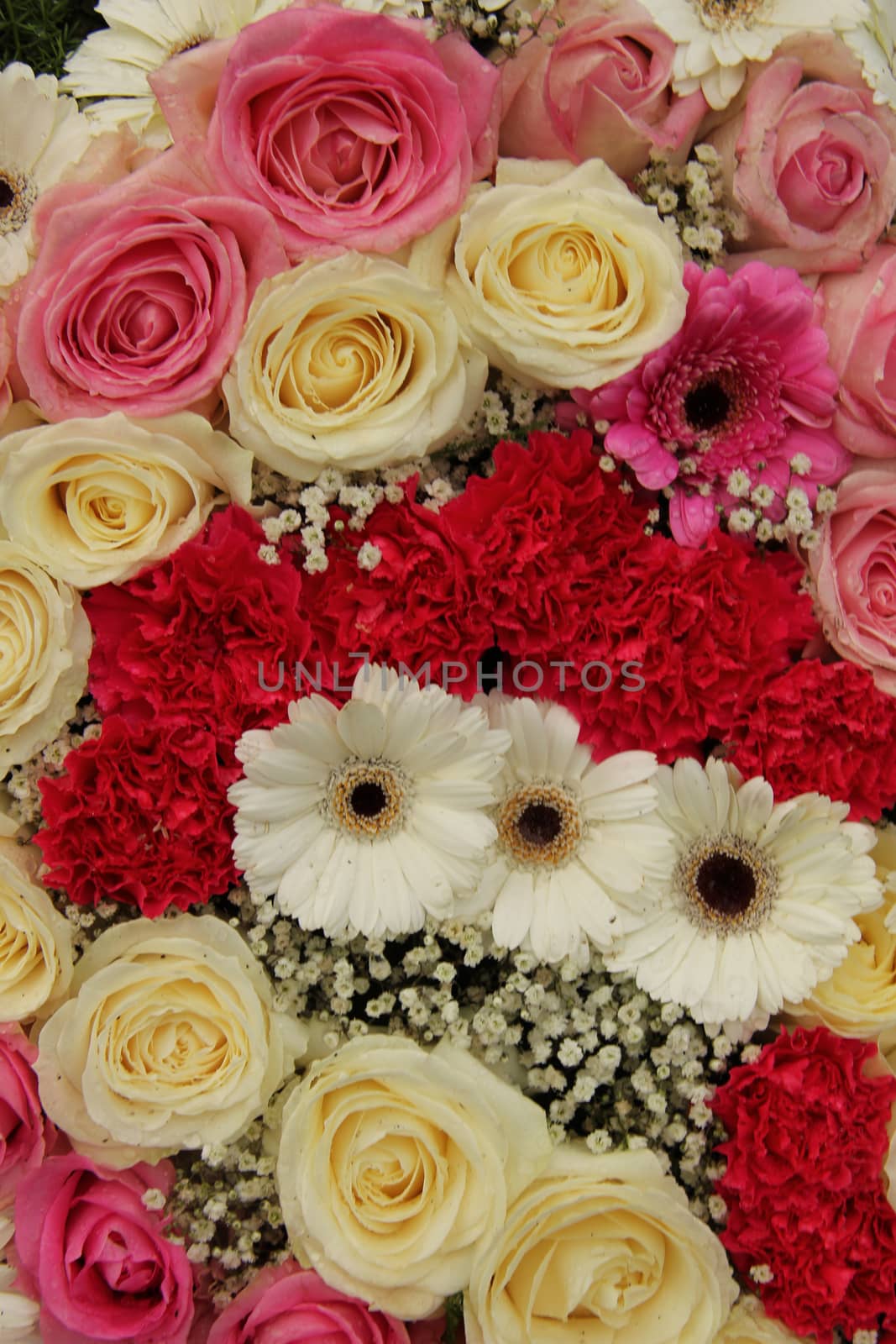 pink and white roses, together with carnations and gerberas in a wedding centerpiece