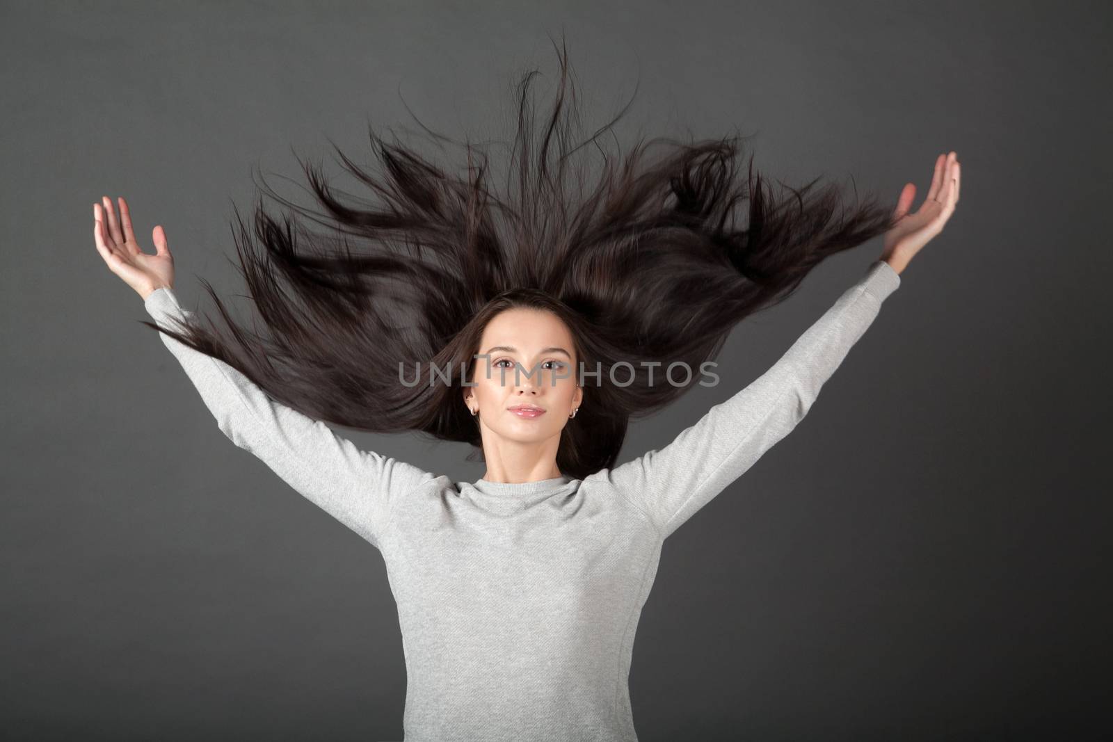 Woman on a gray background hair throws up.