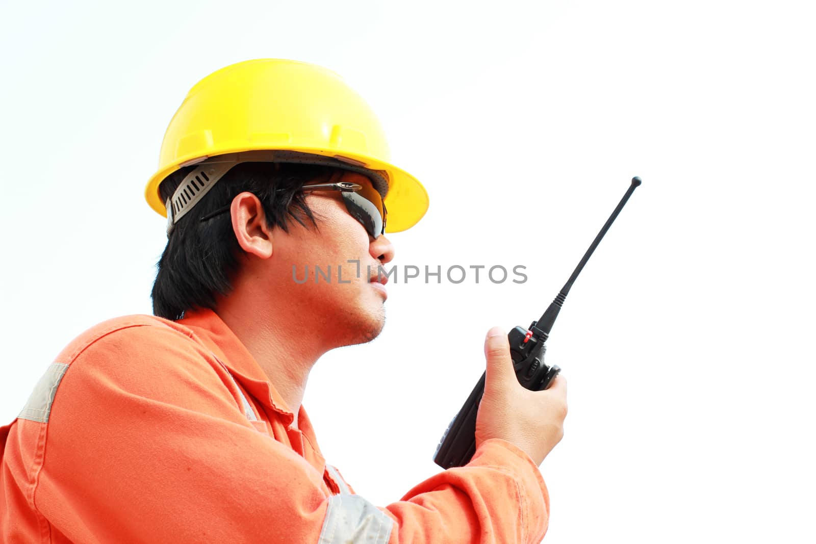 isolated white background. young man communicating on walkie-talkie at site by ZONETEEn