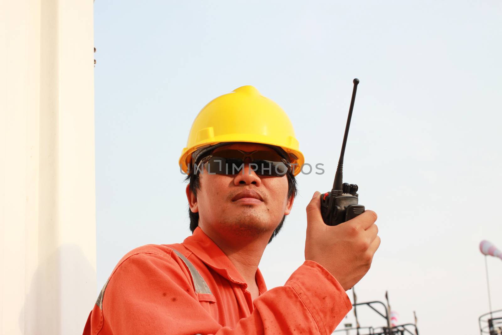 isolated white background. young man communicating on walkie-talkie at site