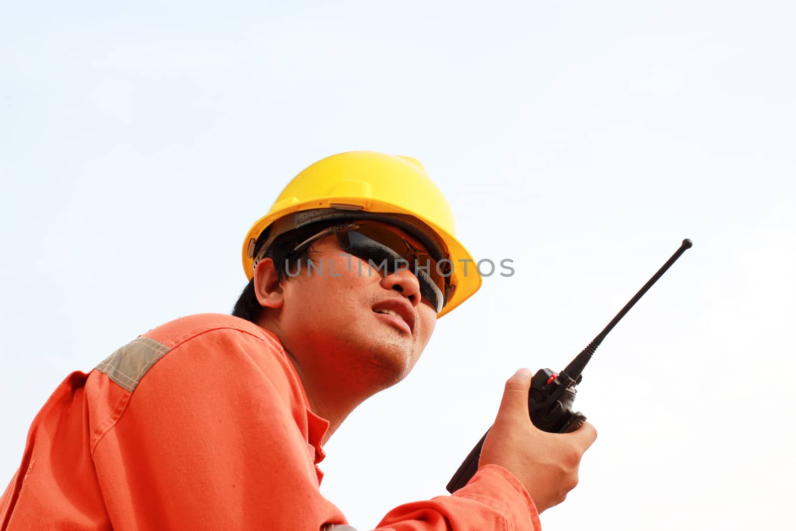 isolated white background. young man communicating on walkie-talkie at site by ZONETEEn