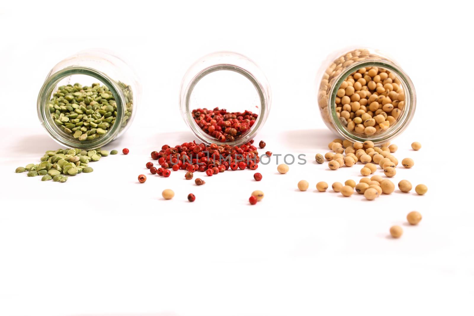 Variety of spices and legumes in a glass pot.
