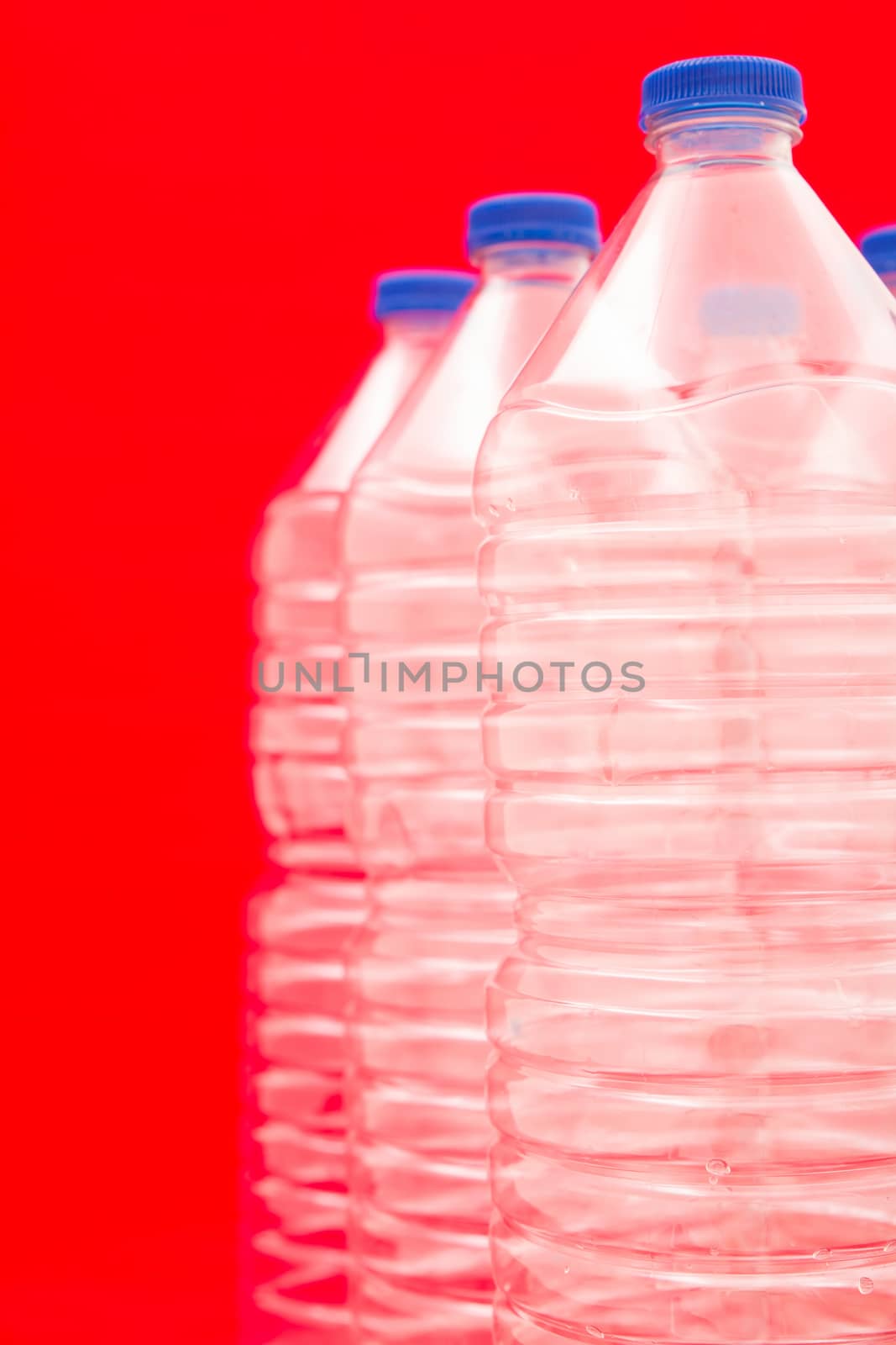 Empty bottles of mineral water with red background