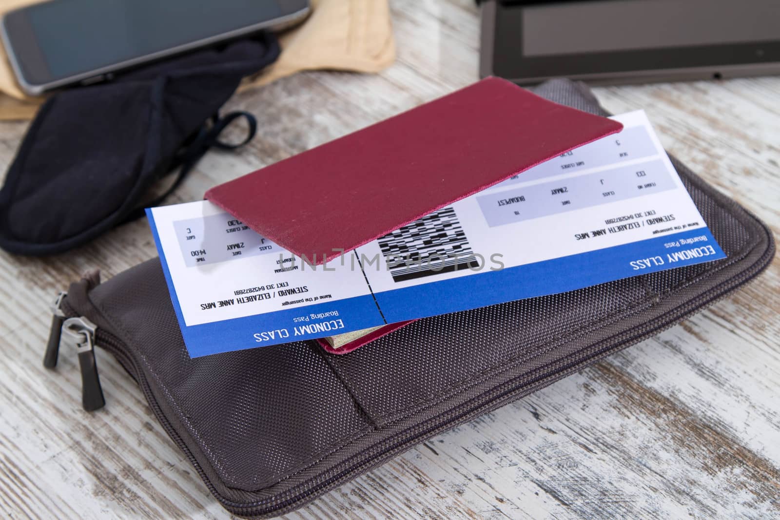 Airline ticket, passport and electronics, preparing to travel
