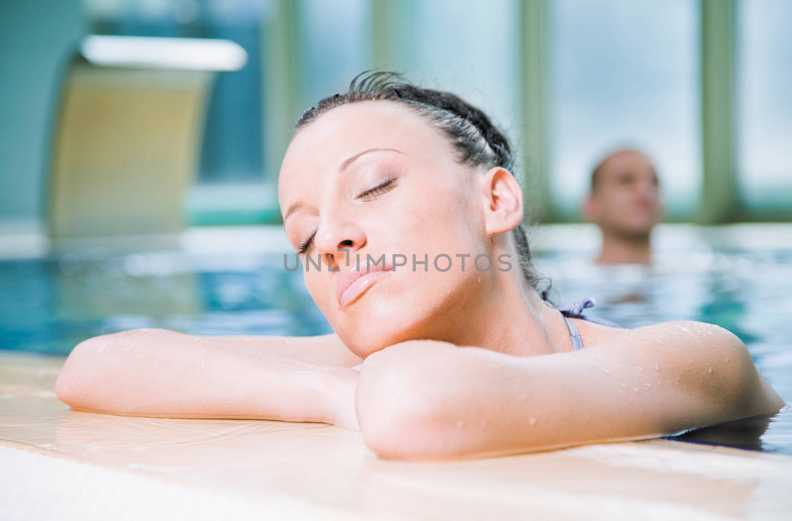 Young attractive female relaxing in a swimming pool