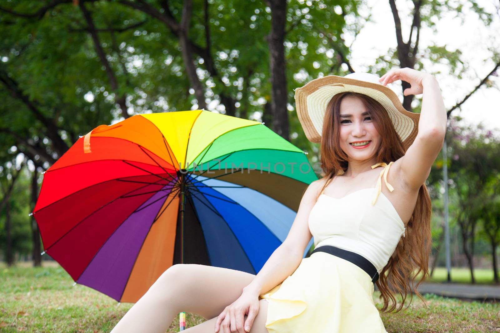 Woman sitting on the grass in the park. Posture relaxed and happy.