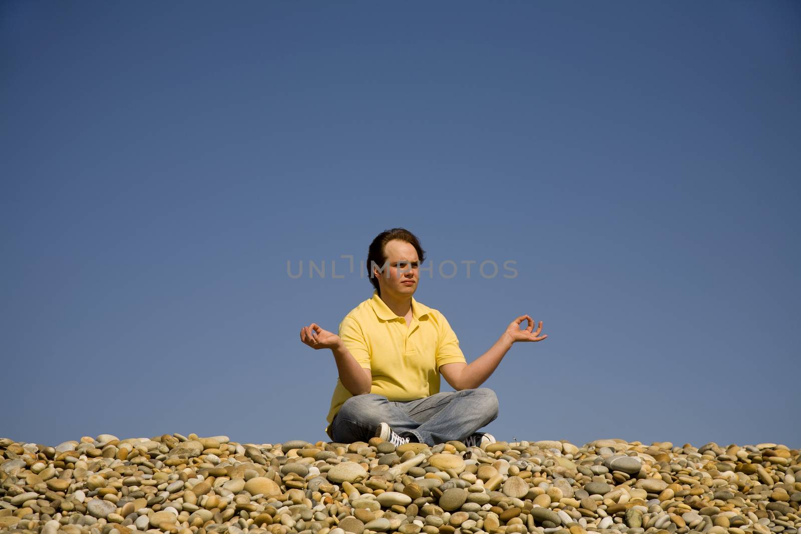 young man at the beach in meditation