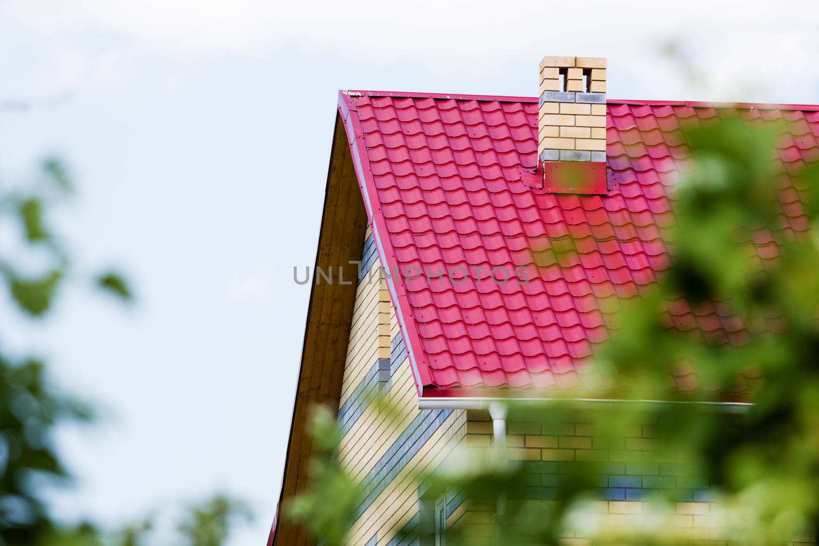 Red roof brick house on a background of the summer sky