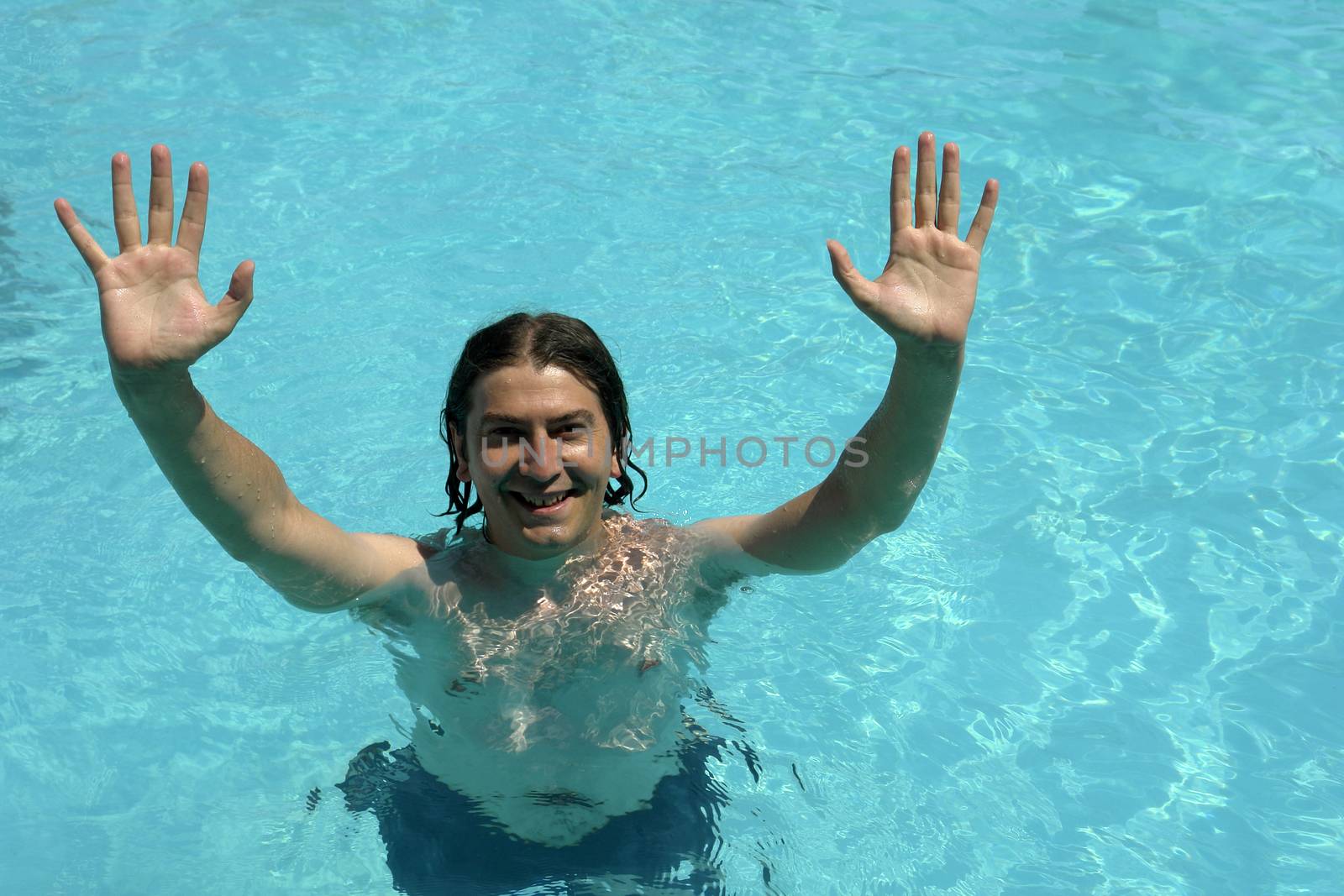young man in a blue swimming pool, with open arms