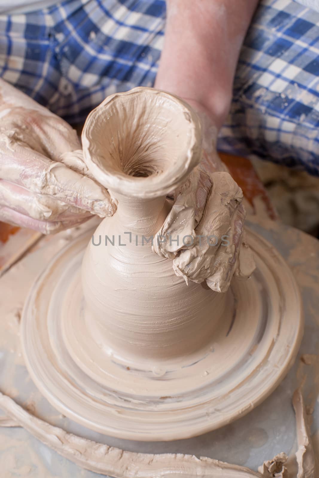 Hands of a potter, creating an earthen jar on the circle