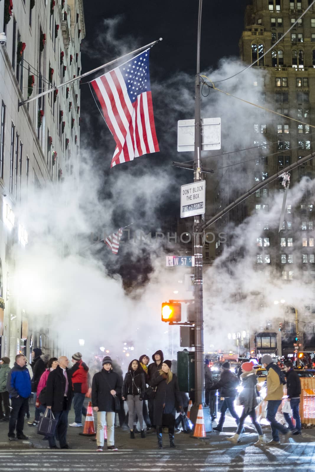 NEW YORK, US - NOVEMBER 25: Pedestrians waiting to cross street under dense steam from nearby road works. November 25, 2013 in New York.