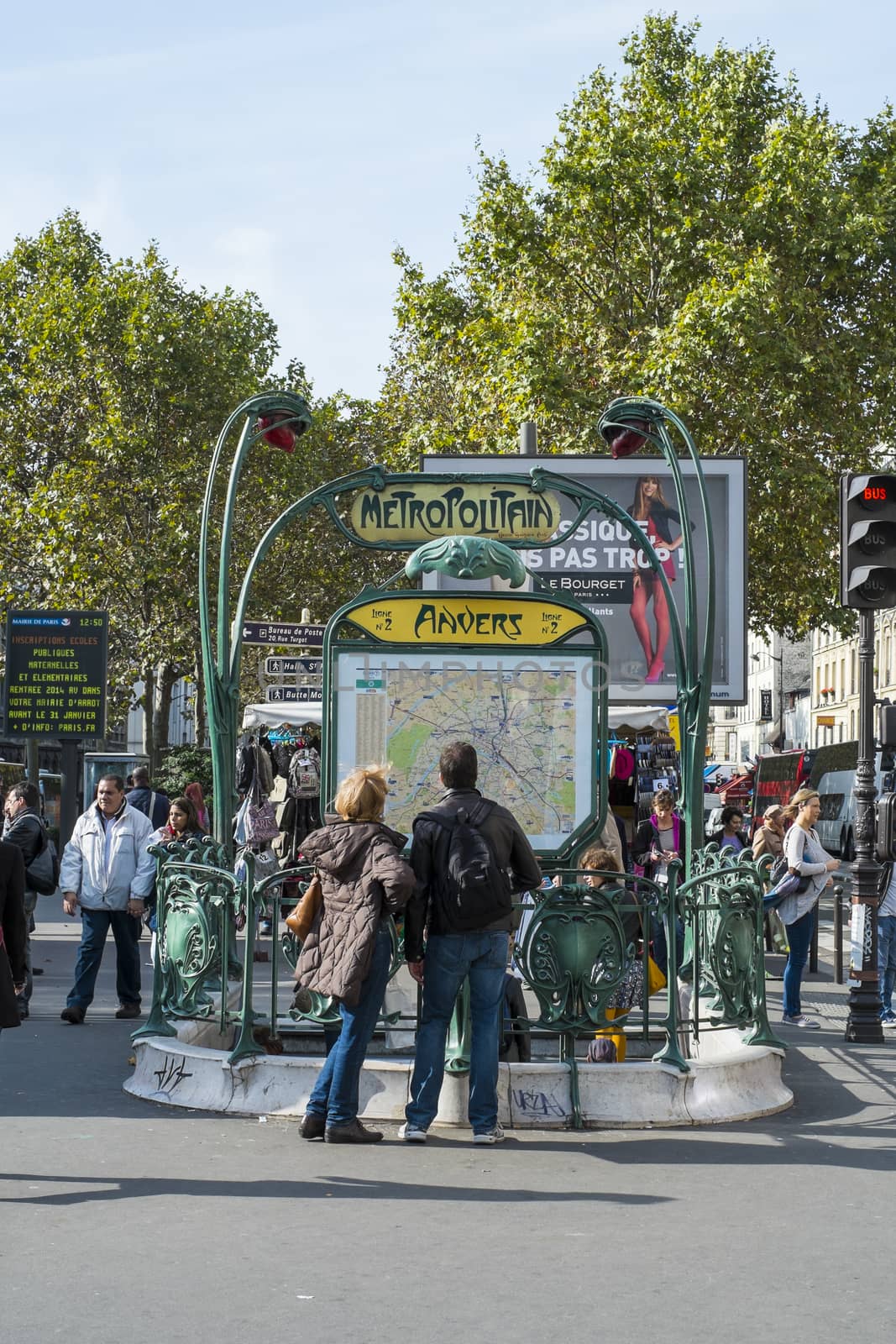 Paris, FRANCE - OCTOBER 19: Tourists looking at map outside Anvers metro station, close to the Sacre Coeur. October 19, 2013 in Paris.
