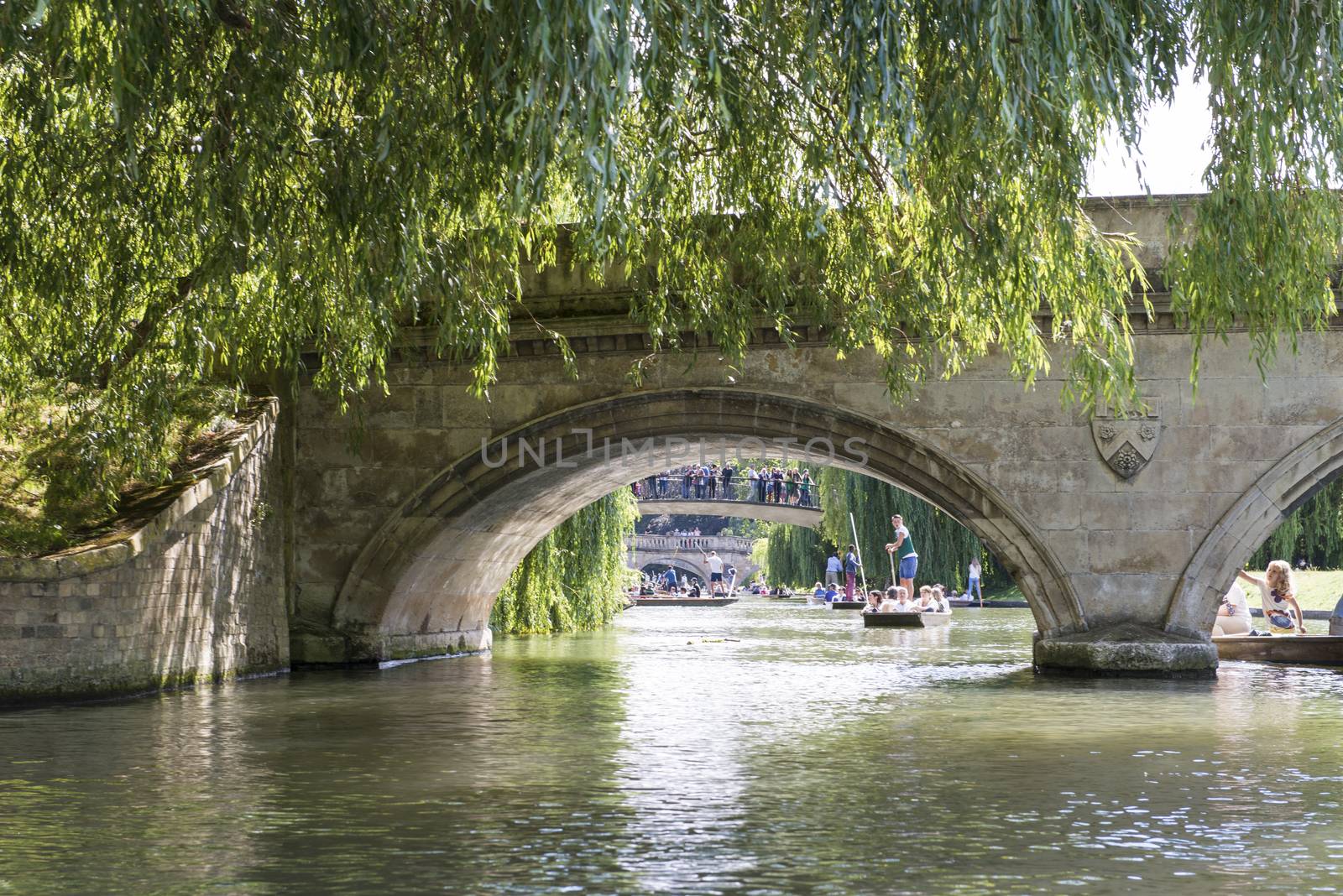 CAMBRIDGE, UK - AUGUST 18: Details of the oldest bridge in Cambridge, Claire Bridge, and busy River Cam full of tourist punter in gondolas in the background. August 18, 2013 in Cambridge.