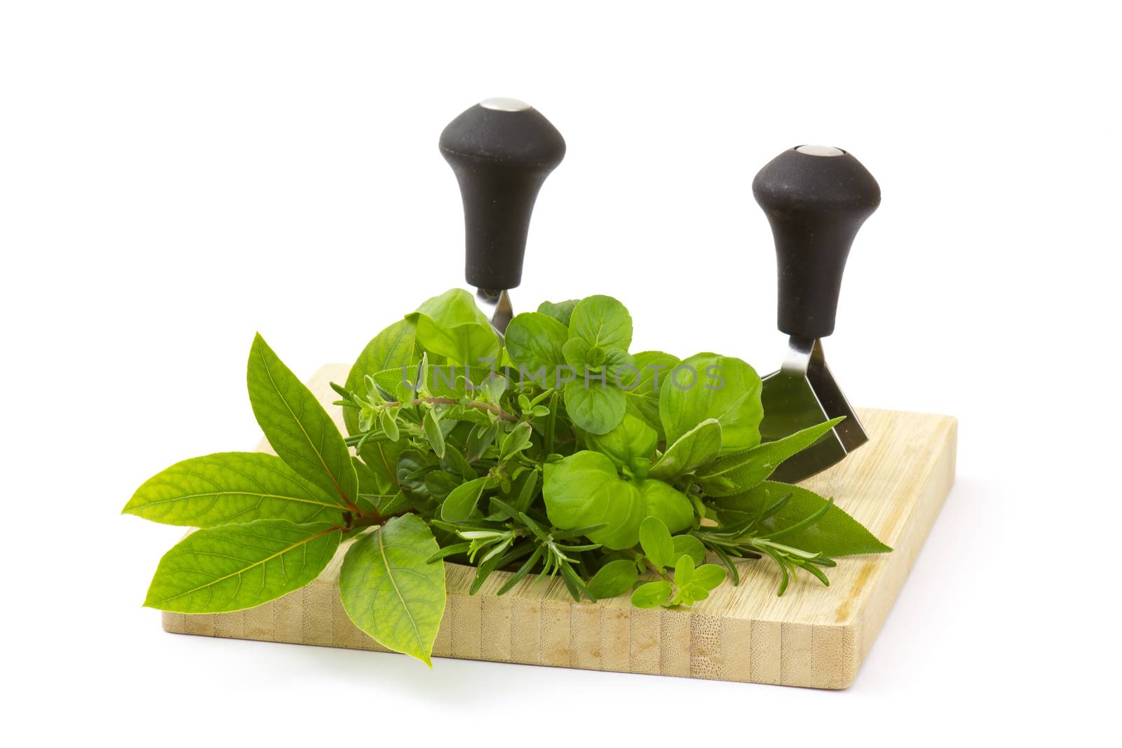 Freshly harvested herbs with knife on wooden board, white background