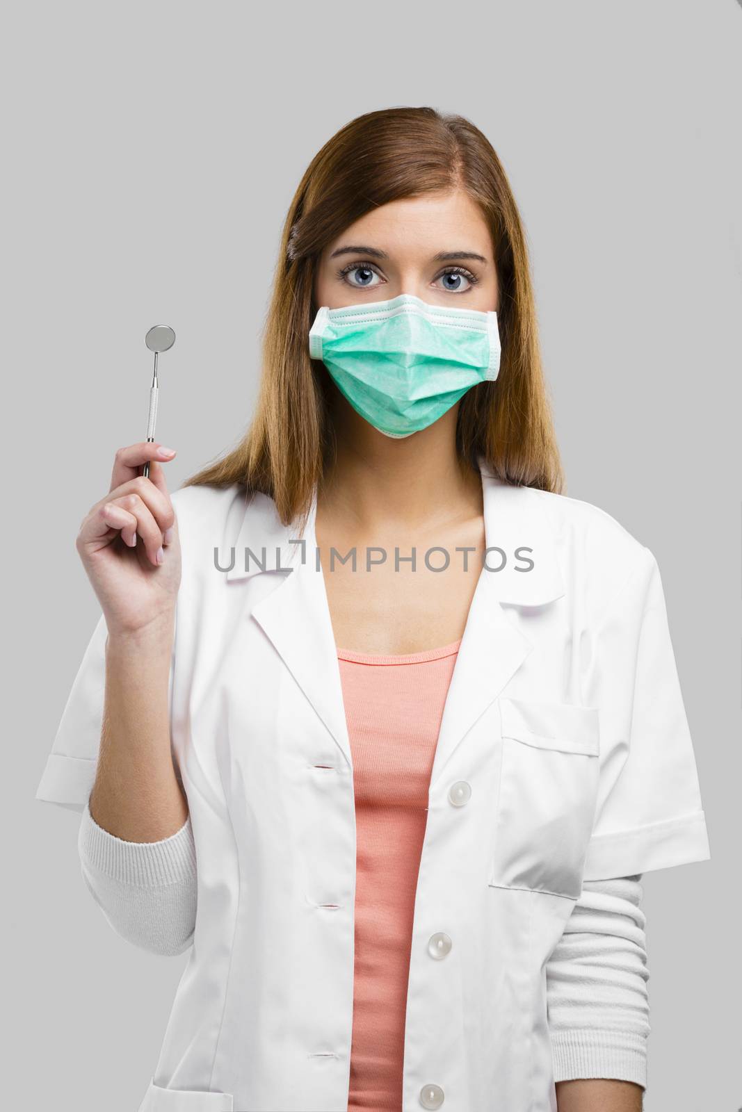 Beautiful and attractive female dentist with tools, isolated over a white background