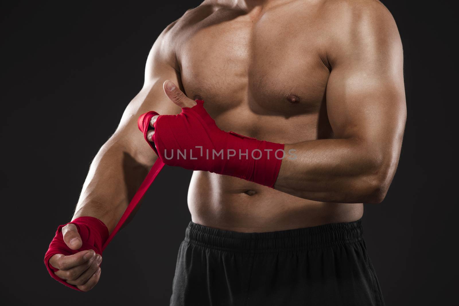 Portrait of a body combat athlet aplying tape on the hands