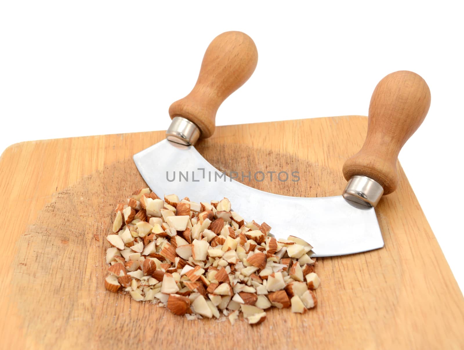 Chopped almonds with a rocking knife on a wooden chopping board