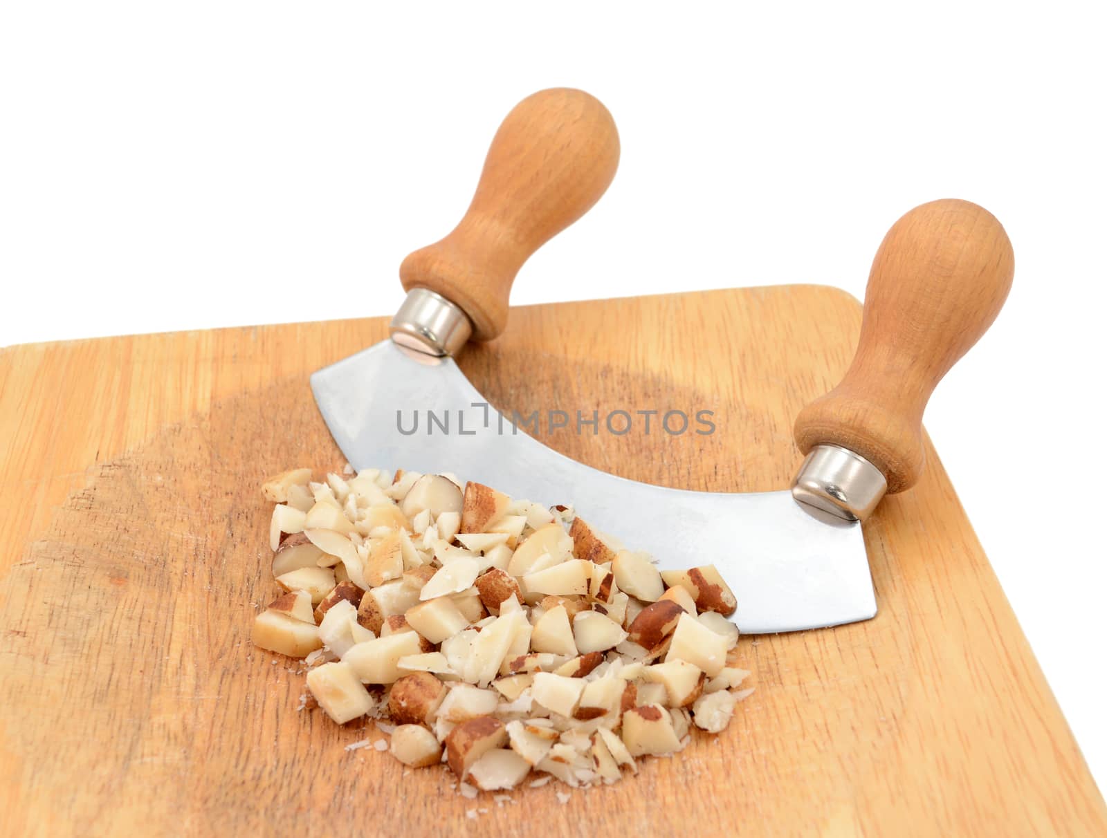 Chopped brazil nuts with a rocking knife on a wooden chopping board