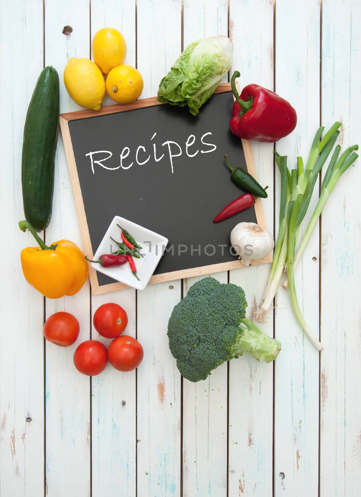 Recipes handwritten on a chalkboard surrounded by fresh ingredients 