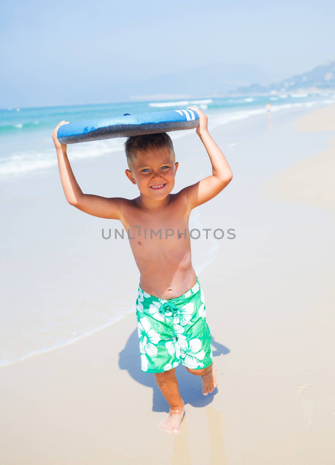 Boy has fun on the surfboard in transparency sea