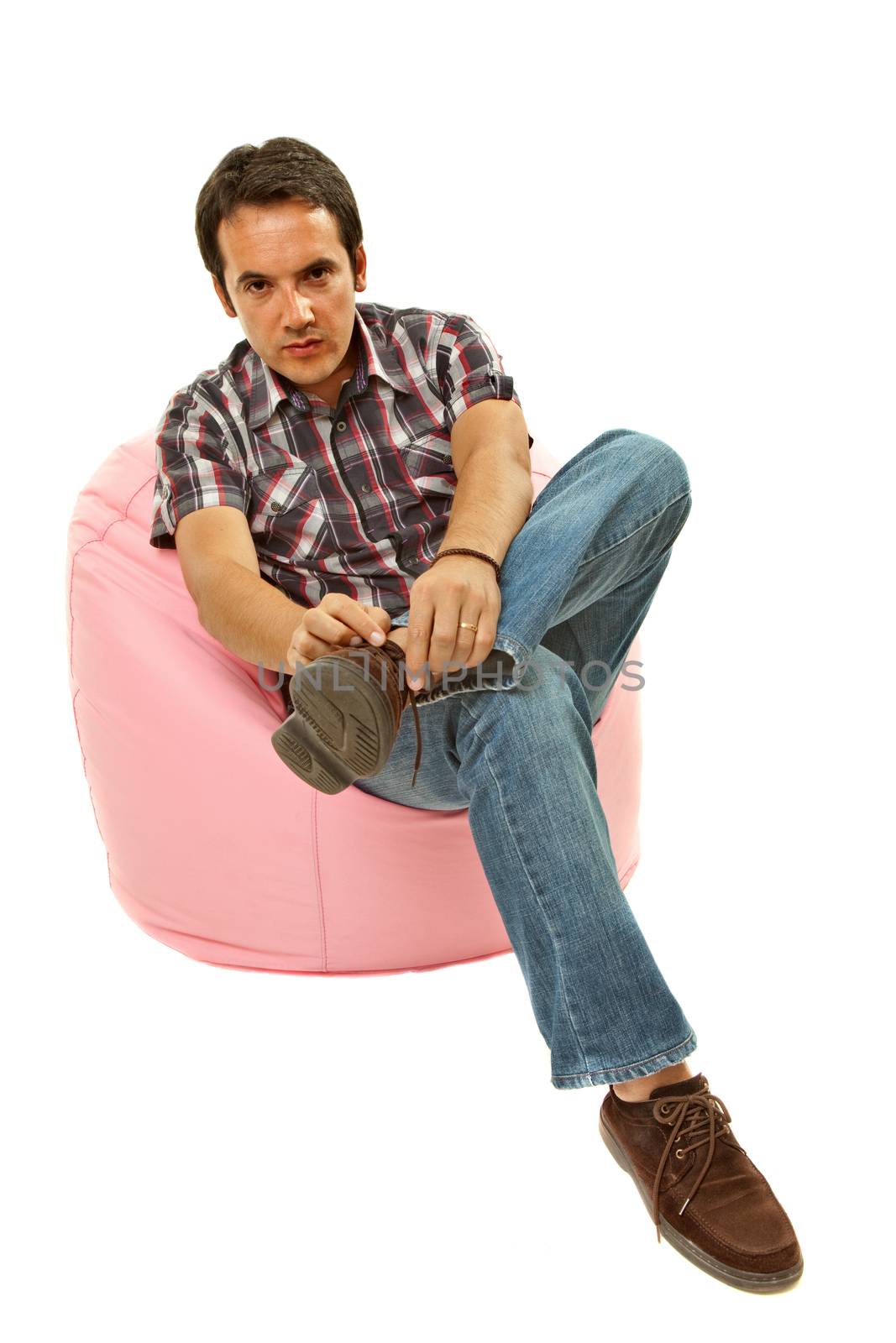 young casual man seated in a small sofa