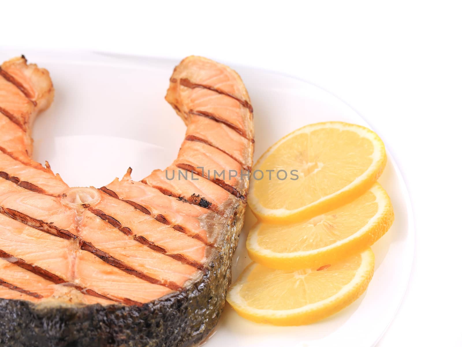 Fresh grilled salmon steak with lemon. Whole background.