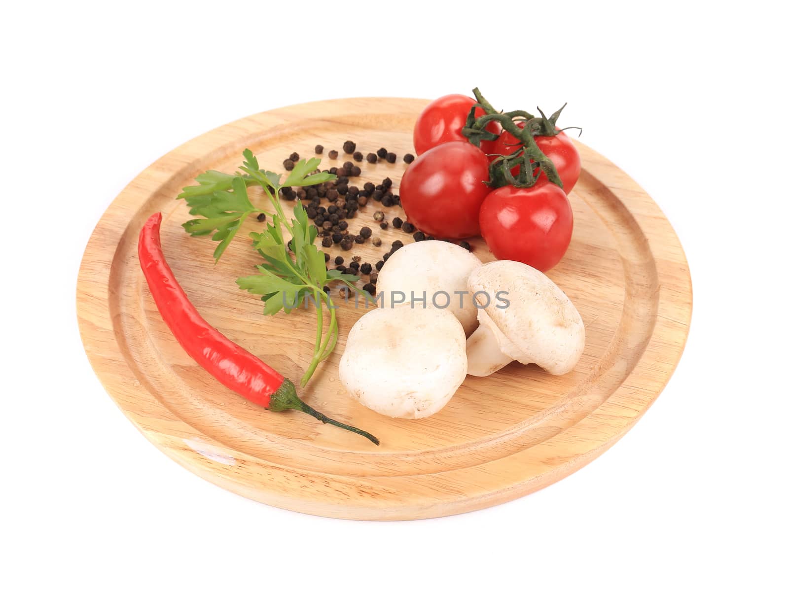 Vegetables on wooden platter. Isolated on a white background.