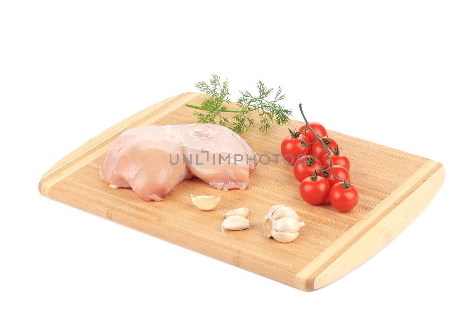 Raw chicken breast and vegetables on wooden board. Isolated on a white background.