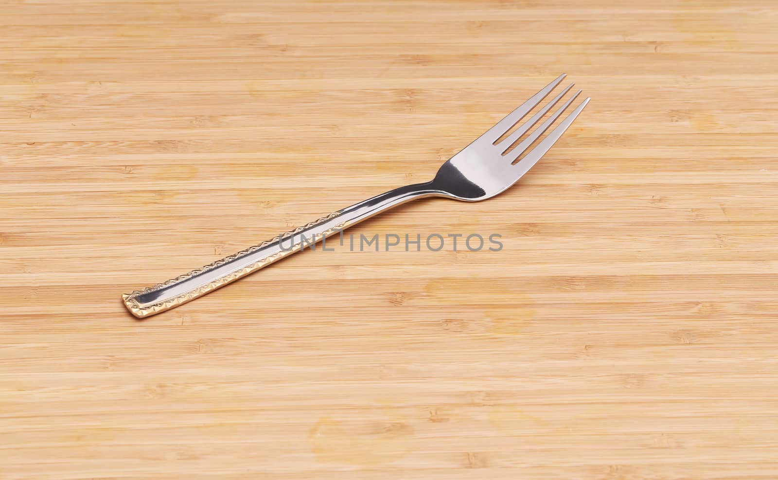 Fork on wooden texture. Close up. Whole background.