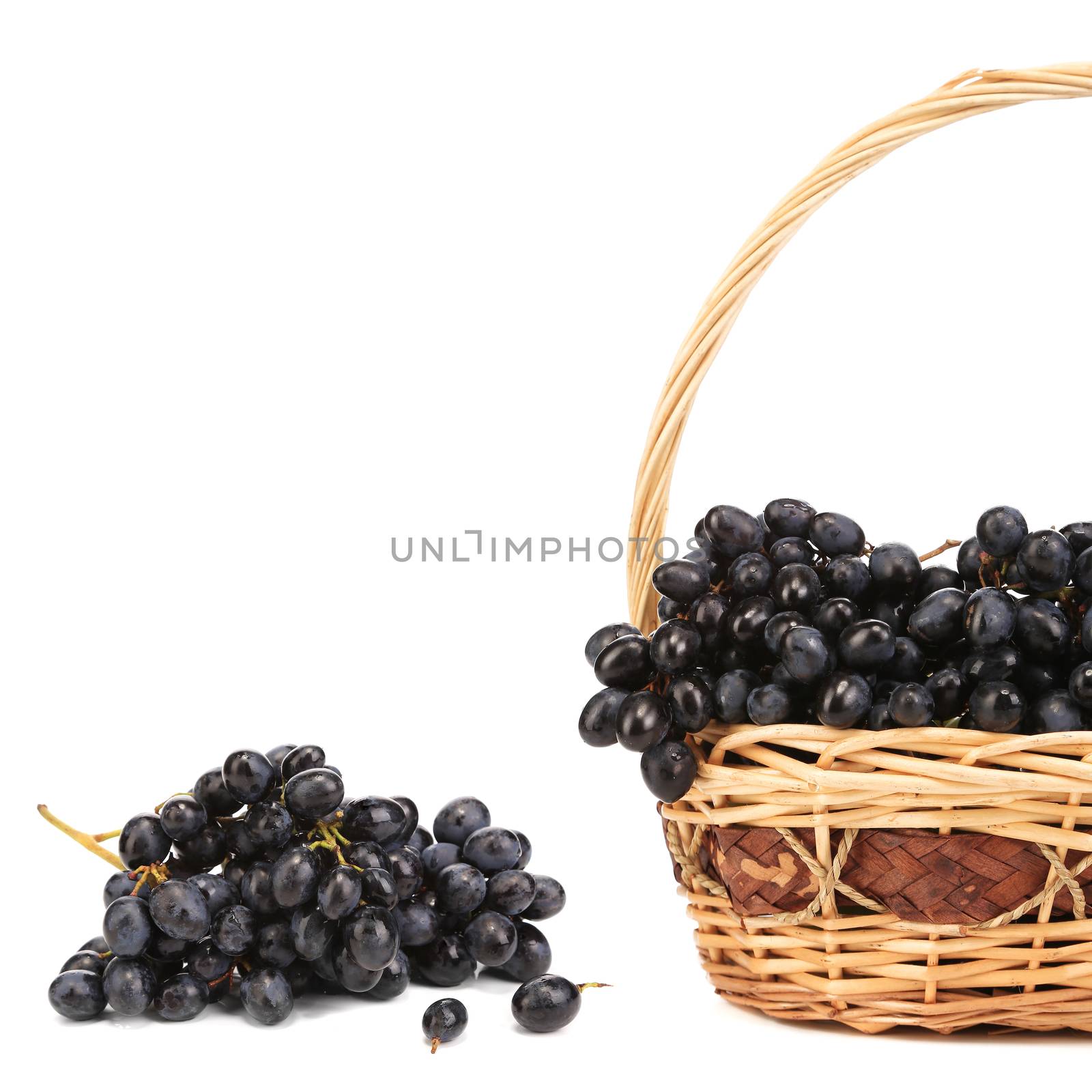 Dark grapes in a wicker basket. Whole background.