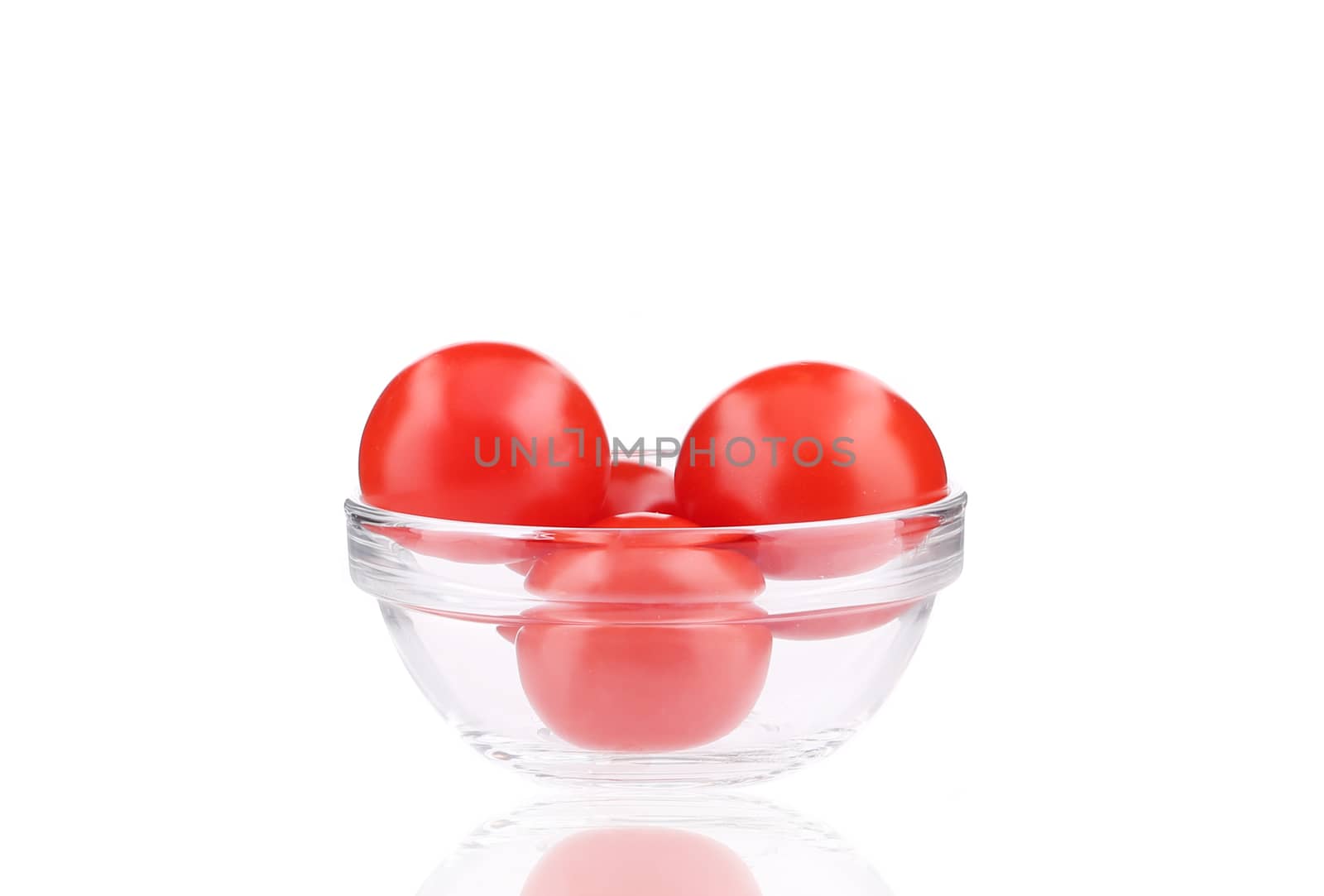 Glass bowl with tomatoes. Isolated on a white background.