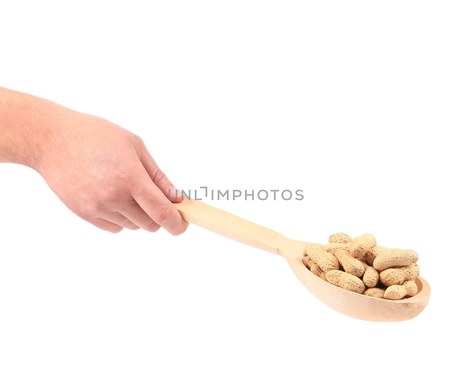 Hand holds wooden spoon with peanuts. Isolated on a white background.