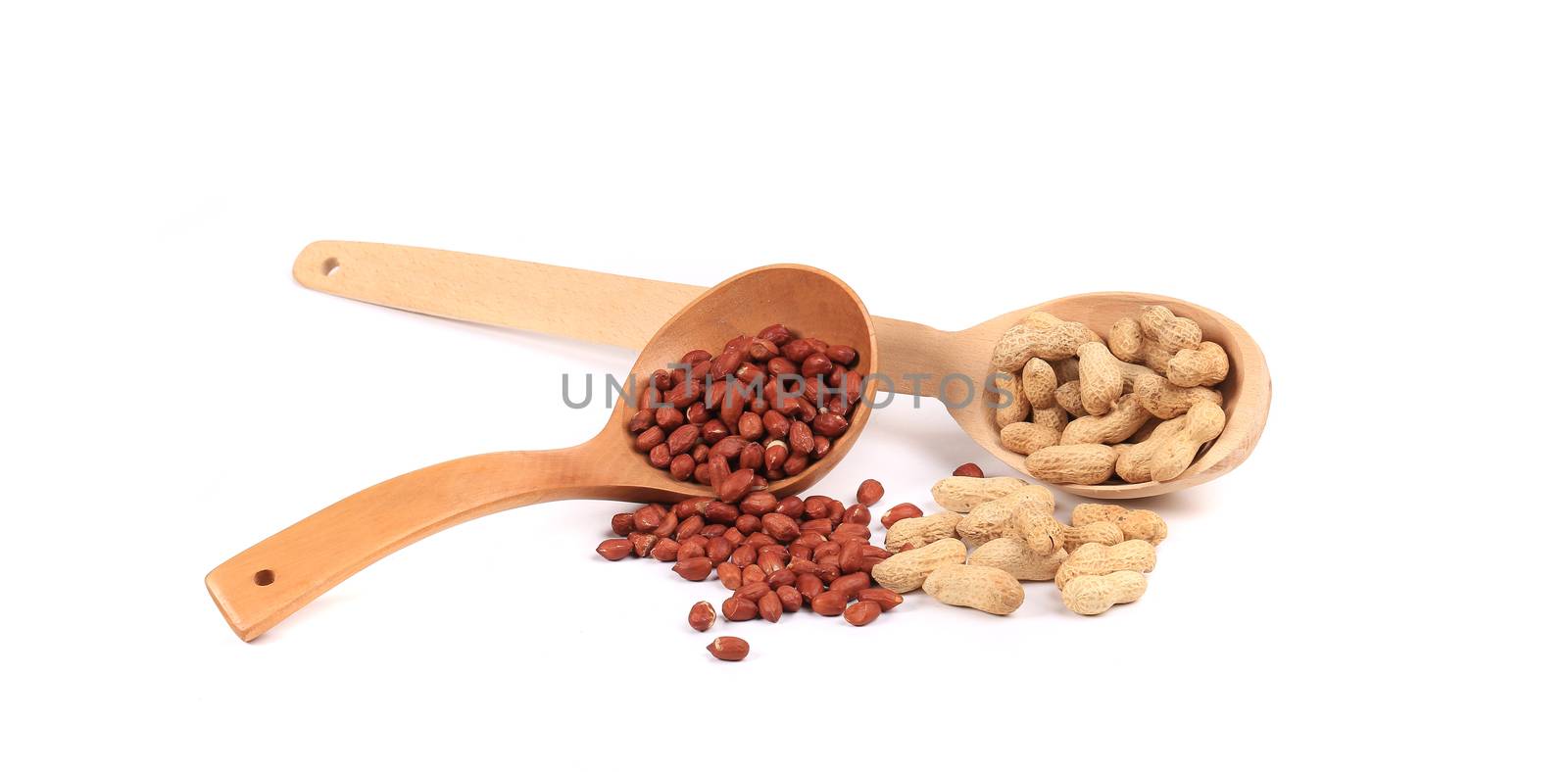 Wooden spoons with peanuts. Isolated on a white background.